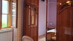A bedroom with a bed, wooden wardrobe, and a window with curtains. - Vacation home Corrado 2 (Toscana)