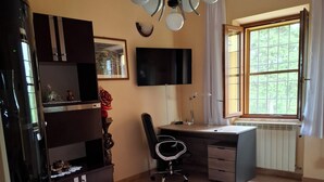 A room with a desk, chair, and a television mounted on the wall. - Vacation home Corrado 2 (Toscana)