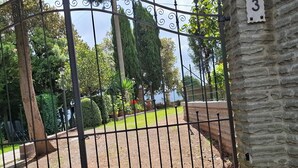 A gated entrance with a stone wall and a number sign. - Vacation home Corrado 2 (Toscana)