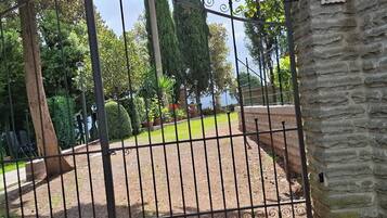 Una entrada protegida por un muro de piedra y un cartel con número.
