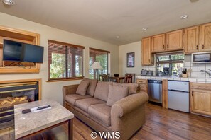 Cozy living space with a fireplace, flat-screen TV, and fully equipped kitchen.