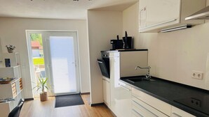 Eine moderne Küche mit schwarzem Arbeitsplatz, weißen Schränken und einem eingebauten Ofen.