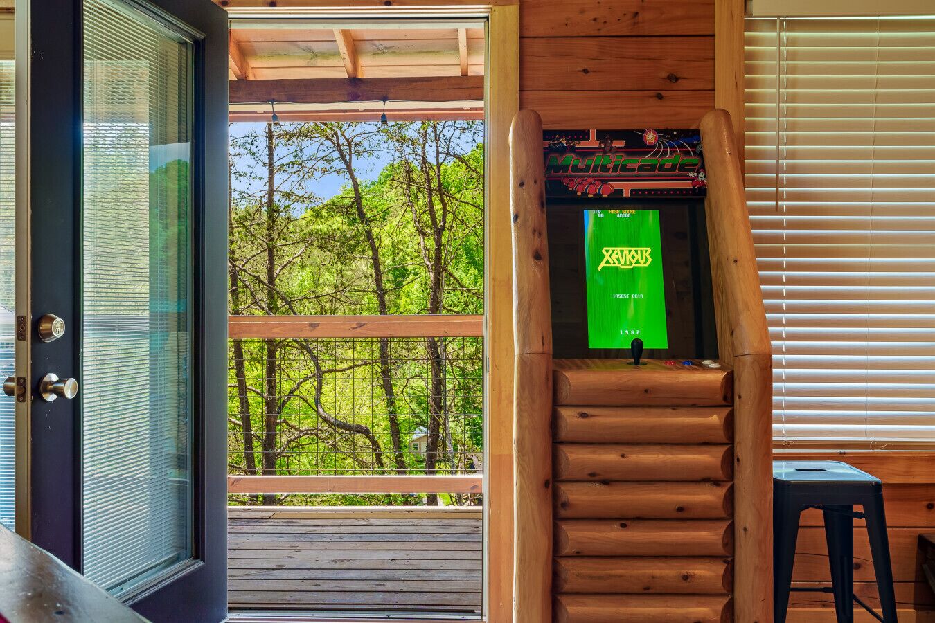 Un escalier en bois mène à une terrasse d’où l’on peut admirer la vue sur les arbres.