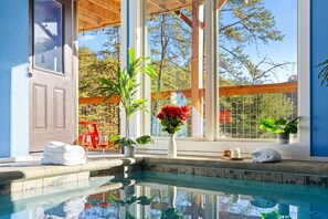 A pool area with a clear view of the surrounding landscape, a wooden pergola, and a window with a view of trees and a fence. - Smokies Couple Getaway (Sevierville)
