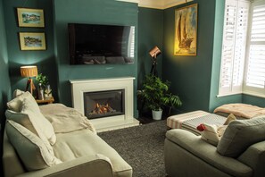 Smart-TV, peis, bøker og stereoanlegg