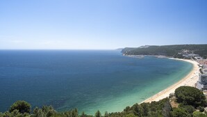 A coastal view with a beach, clear blue sea, and a hilly landscape. - Coastline Arrabida Villa by Cadenzalux (Sesimbra)