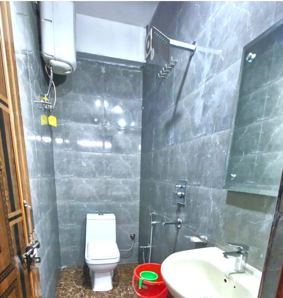 A bathroom with a toilet, shower, and sink.