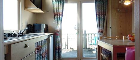 A compact kitchen with a microwave, stove, and a small dining area with a table and chairs.