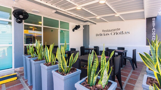 An outdoor seating area with potted plants, tables, and chairs. - Hotel Med Cartagena (Cartagena)