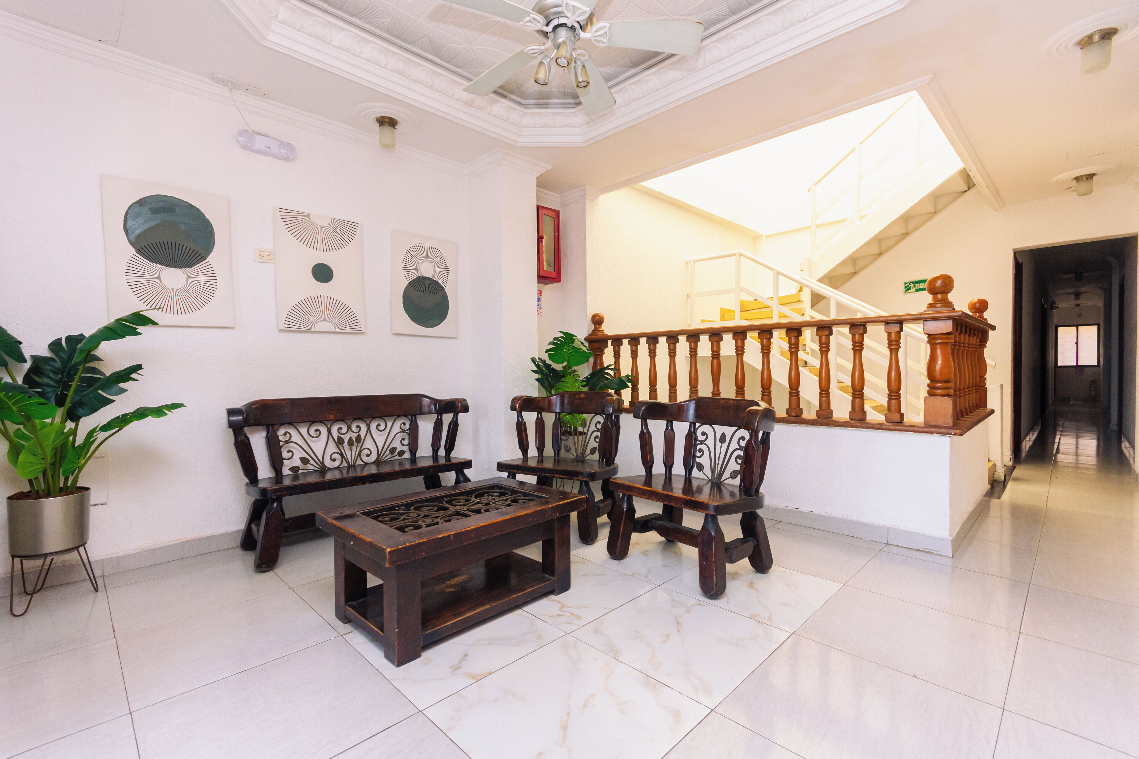 A spacious living area with a wooden coffee table, two sofas, and a staircase with a wooden railing.