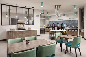 A modern cafe with a central counter, seating area, and coffee machines. - Tru By Hilton Cleveland, TN (Cleveland)