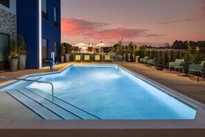 An indoor swimming pool with a view of a sunset, lounge chairs, and umbrellas. - Tru By Hilton Cleveland, TN (Cleveland)