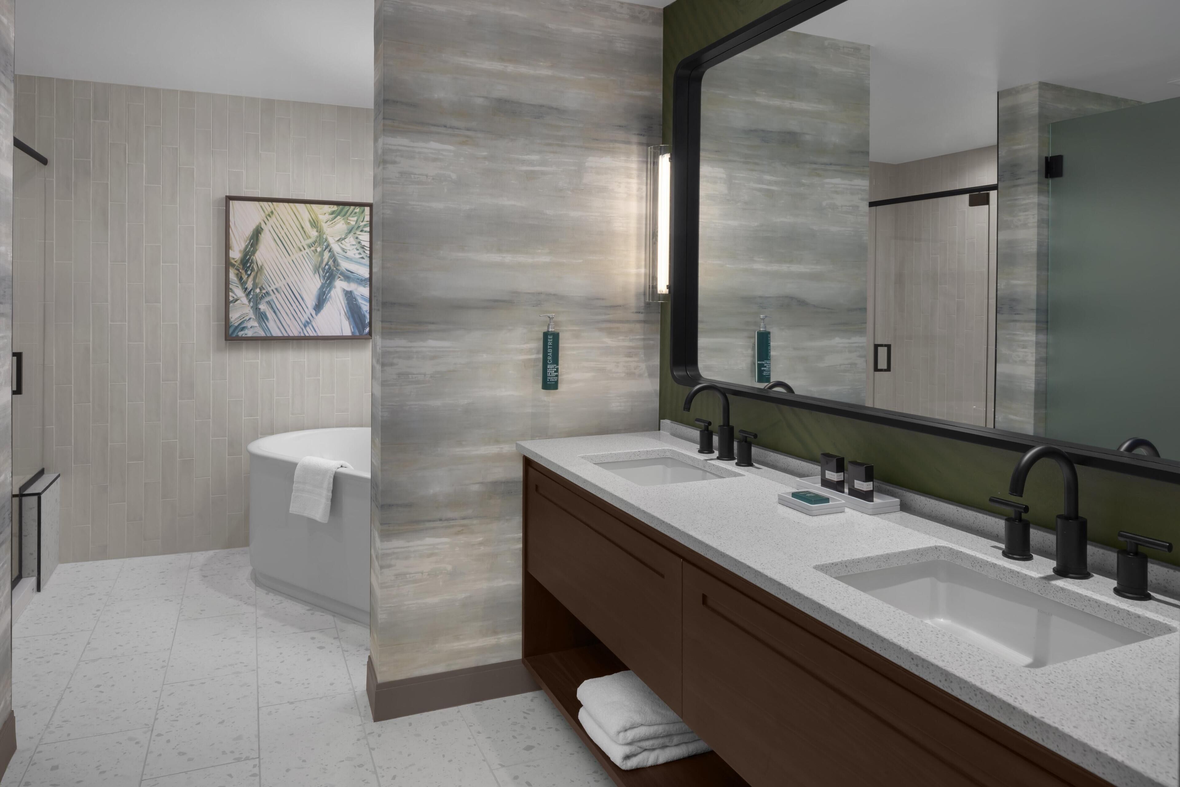 Une salle de bain moderne avec un meuble-lavabo à deux vasques, un grand miroir et une baignoire.
