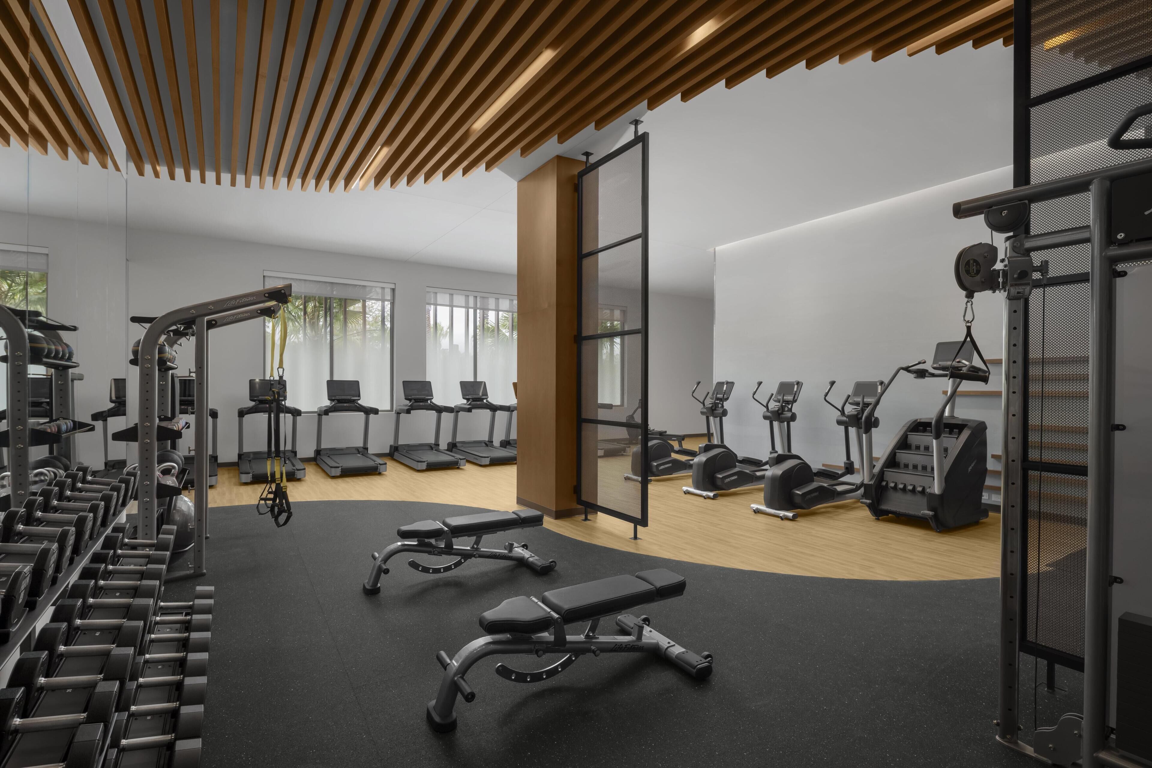 A modern gym with various exercise equipment, treadmills, and weight machines.