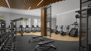 A modern gym with various exercise equipment, treadmills, and weight machines.