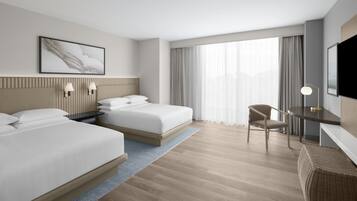 Une chambre d’hôtel moderne équipée de deux lits, d’un bureau, d’une chaise et d’un téléviseur.