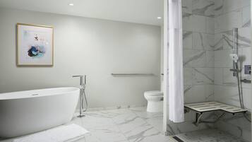 A modern bathroom with a freestanding bathtub, a shower enclosure, and a toilet.