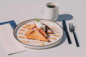 A plate of food with a dessert, a cup of coffee, and a menu on a table. - Hilton Arcadia Pasadena Area (Arcadia)