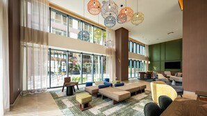 A spacious lobby with large windows, modern seating, and decorative hanging lights. - Hotel Hampton by Hilton Santiago de los Caballeros (Santiago de los Caballeros)