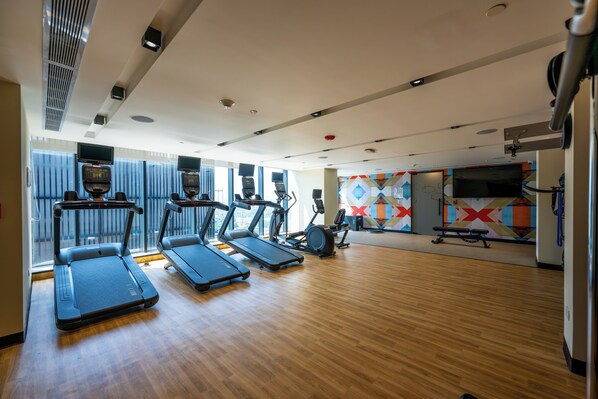 A gym with treadmills, elliptical machines, and a stationary bike.