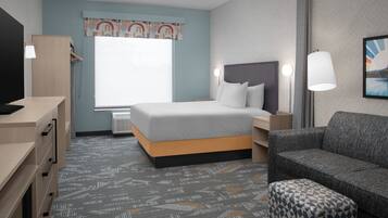 Une chambre d’hôtel avec un lit, un bureau, une chaise et un canapé.