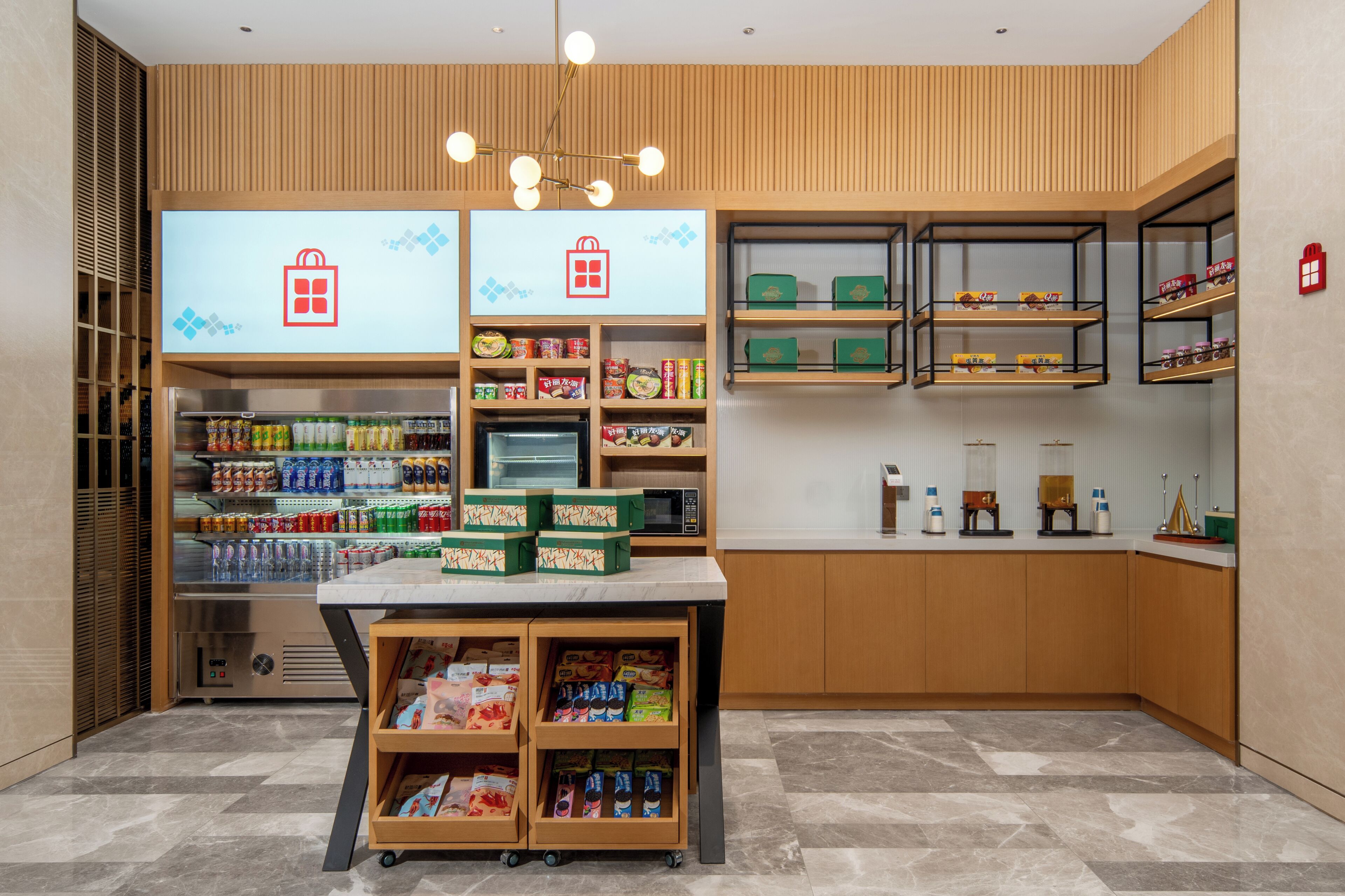 Un espacio comercial moderno con estantes llenos de aperitivos y bebidas, un refrigerador y una caja registradora.