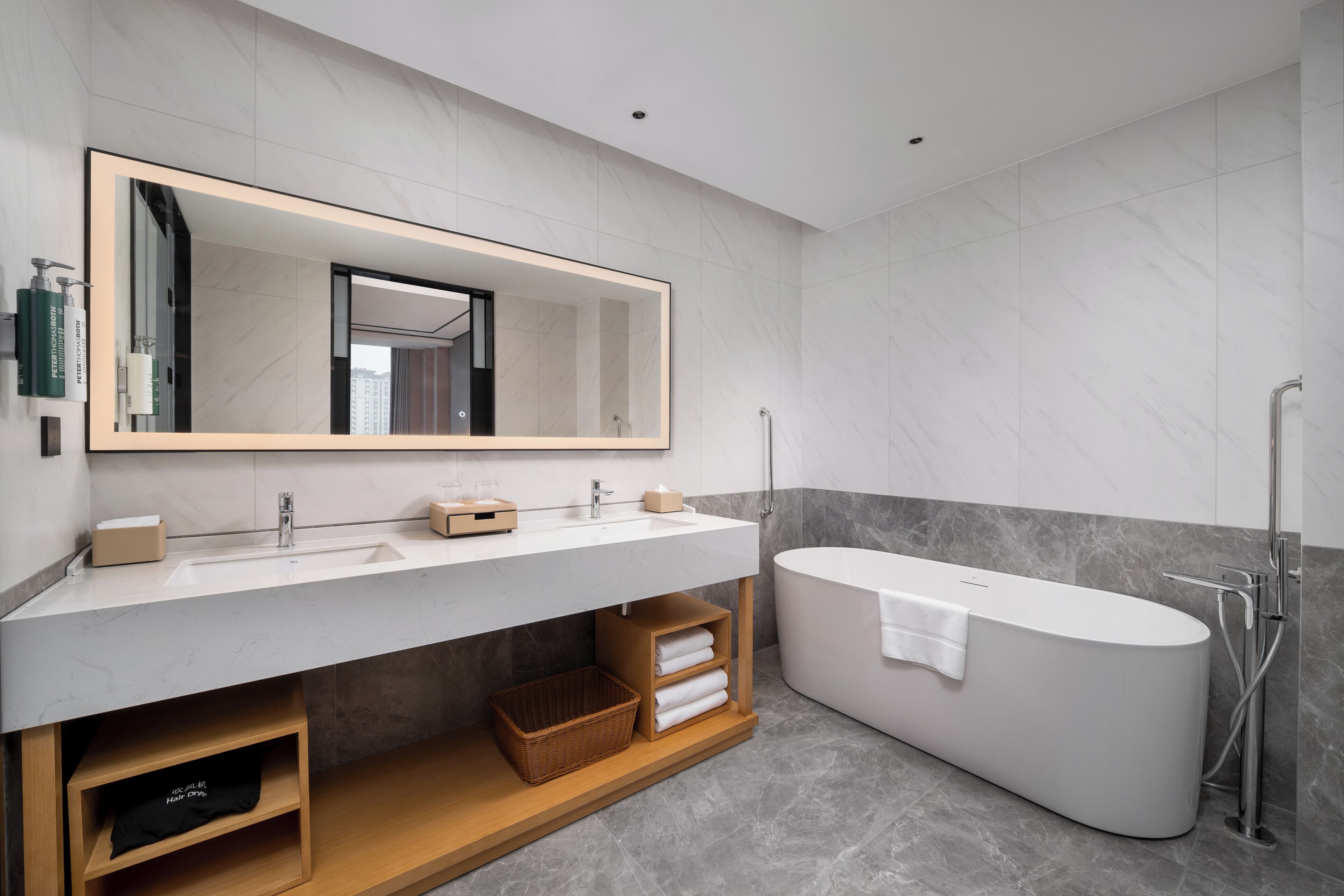 Un baño moderno con un espejo grande, un lavamanos blanco, una bañera y una ducha.