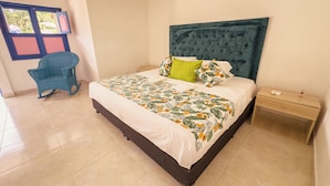 A bedroom with a bed, a nightstand, a chair, and a window with a view. - HOTEL JARDIN DEL RIO  (Betania)
