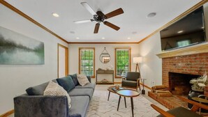 Un salon comprenant un canapé, une table basse, une cheminée et un ventilateur de plafond.