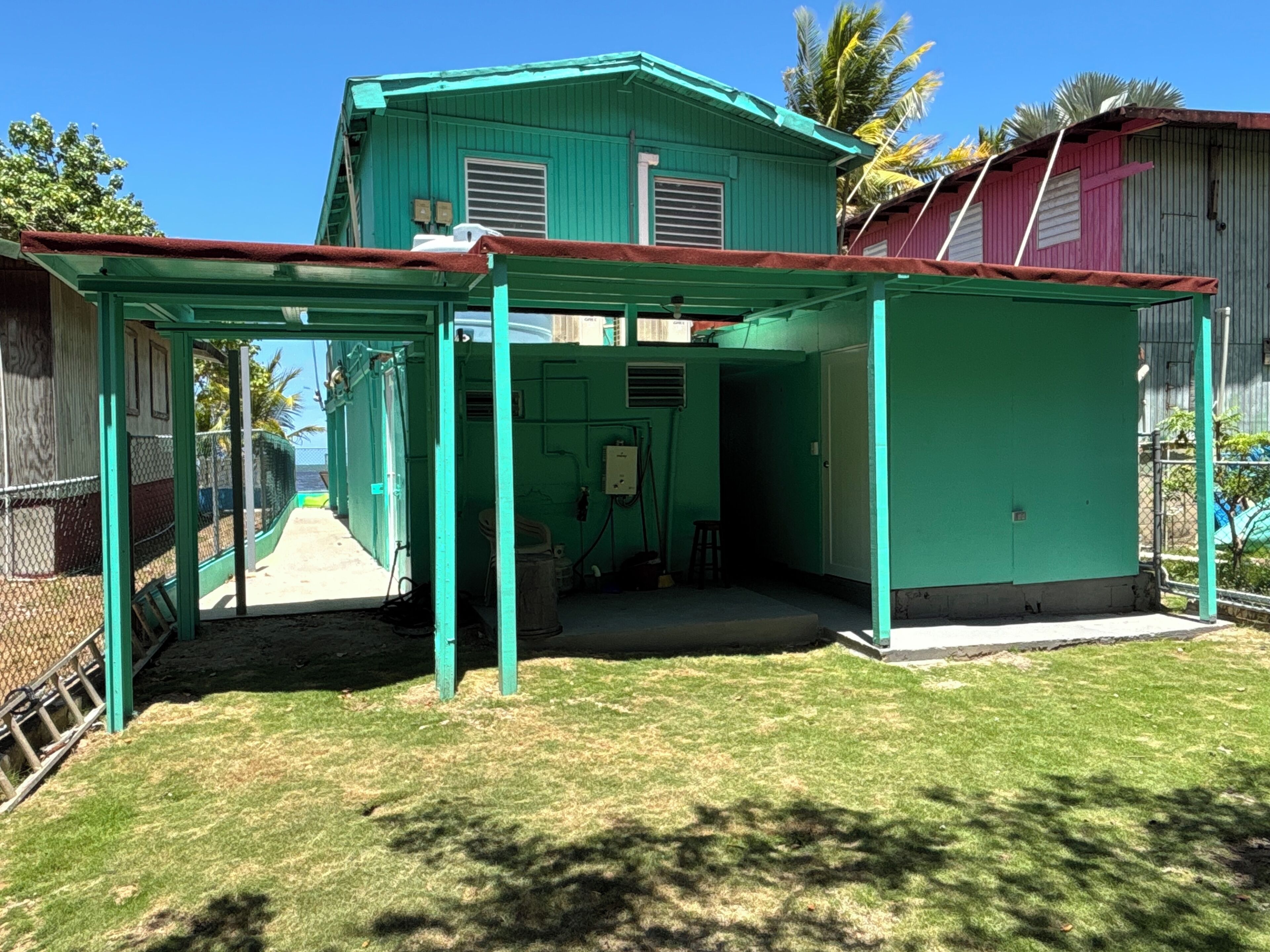 Une maison verte dotée d’un patio couvert.
