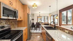 Una cocina moderna con armarios de madera, electrodomésticos de acero inoxidable y encimera de granito.