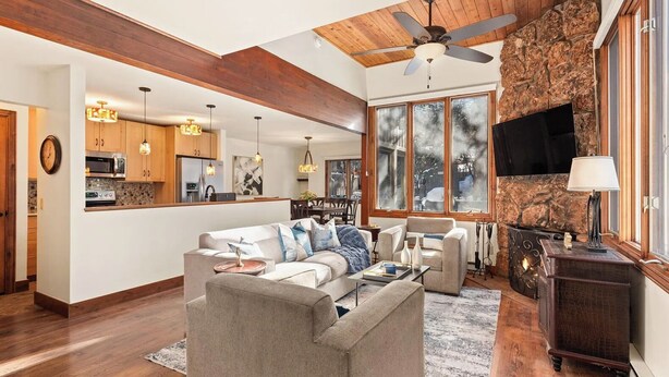Un salón espacioso con chimenea, una zona de cocina y un comedor.