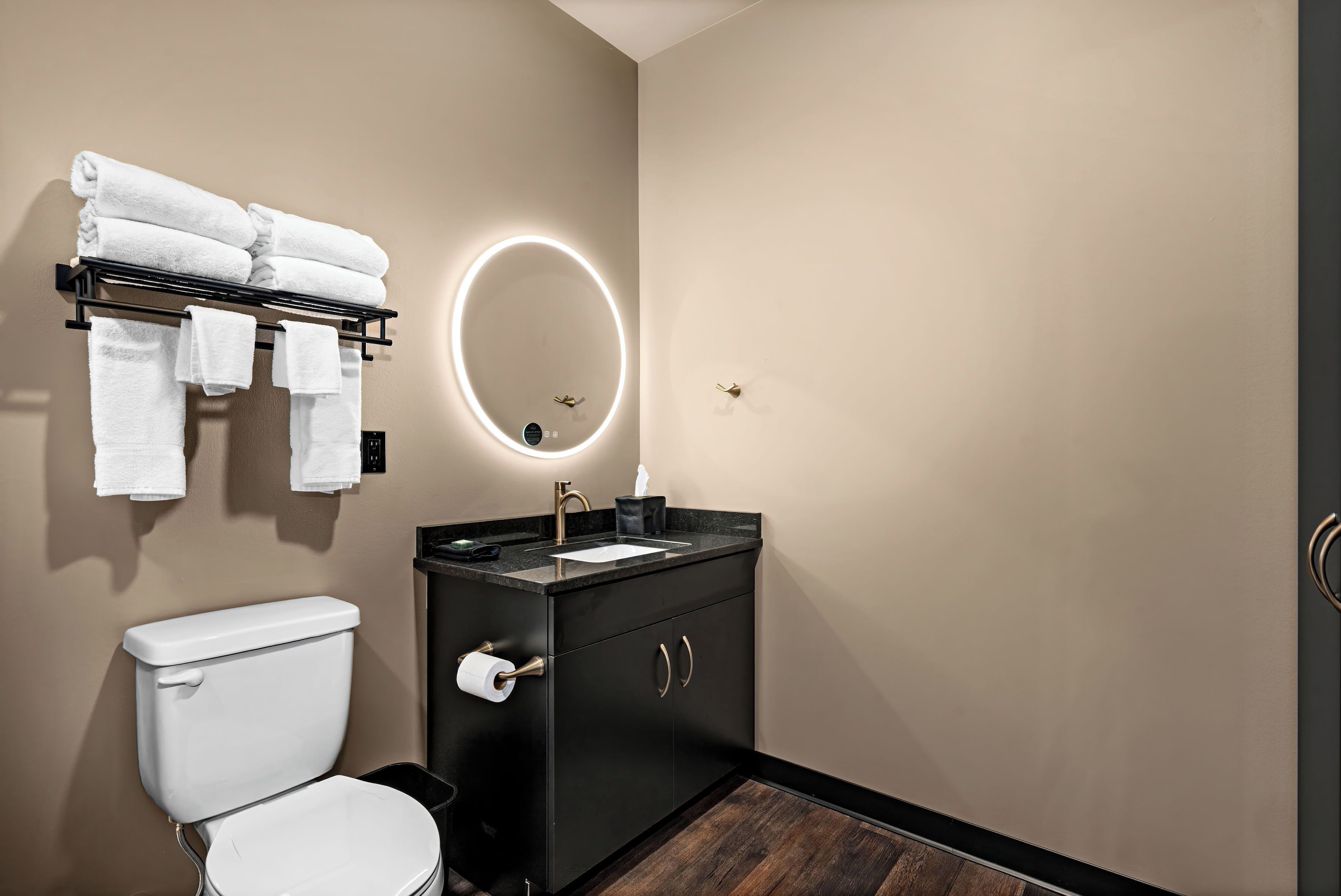 A modern bathroom with a toilet, sink, and towel rack.