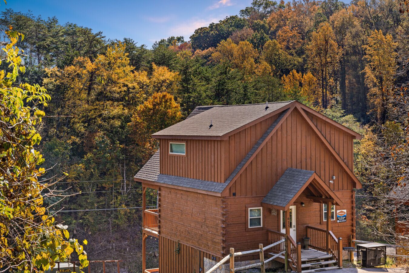 A wooden cabin with a steep roof, a small balcony, and a staircase leading to the entrance.