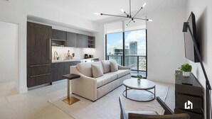 Una sala de estar moderna con un sofá, una mesa de centro y un televisor montado en la pared.