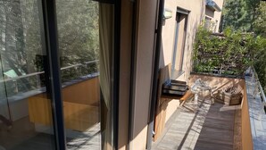 A wooden deck with a table and chairs, a book, and two wine glasses. - 1 bedroom apartment in quiet residence! Peaceful! & Always Sunny! (PROPRIANO)