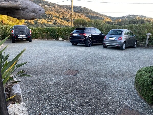 A parking area with three cars parked.