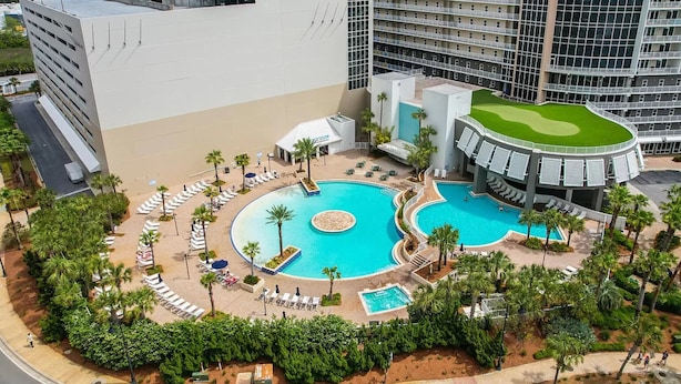 Een resort met een groot centraal zwembad, diverse kleinere zwembaden en een golfbaan.