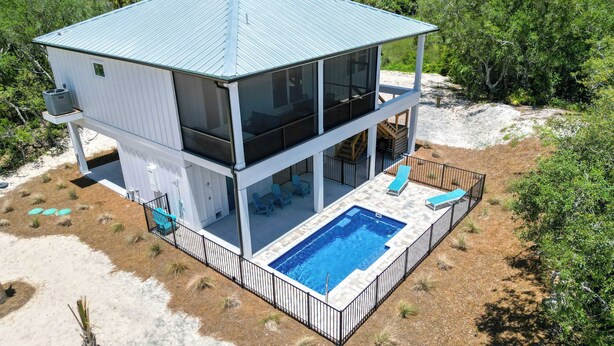 A two-story modern house with a large balcony and a swimming pool. - St George Island Home with Private Pool, Pet Friendly (heated/cooled pool for a fee) (Eastpoint)