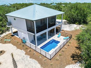A two-story modern house with a large balcony and a swimming pool.
