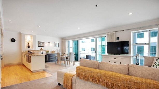 A modern apartment with a kitchen, dining area, and living room. - Space Style and Comfort (Auckland)