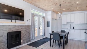 A modern kitchen with white cabinets, a black countertop, and a built-in oven. - Hôtel à la maison - La Cachette, golf et ski! (Adstock)