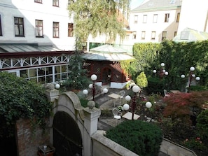 A courtyard with a gazebo, seating area, and a covered walkway. - Hotel Viki (Vienna)