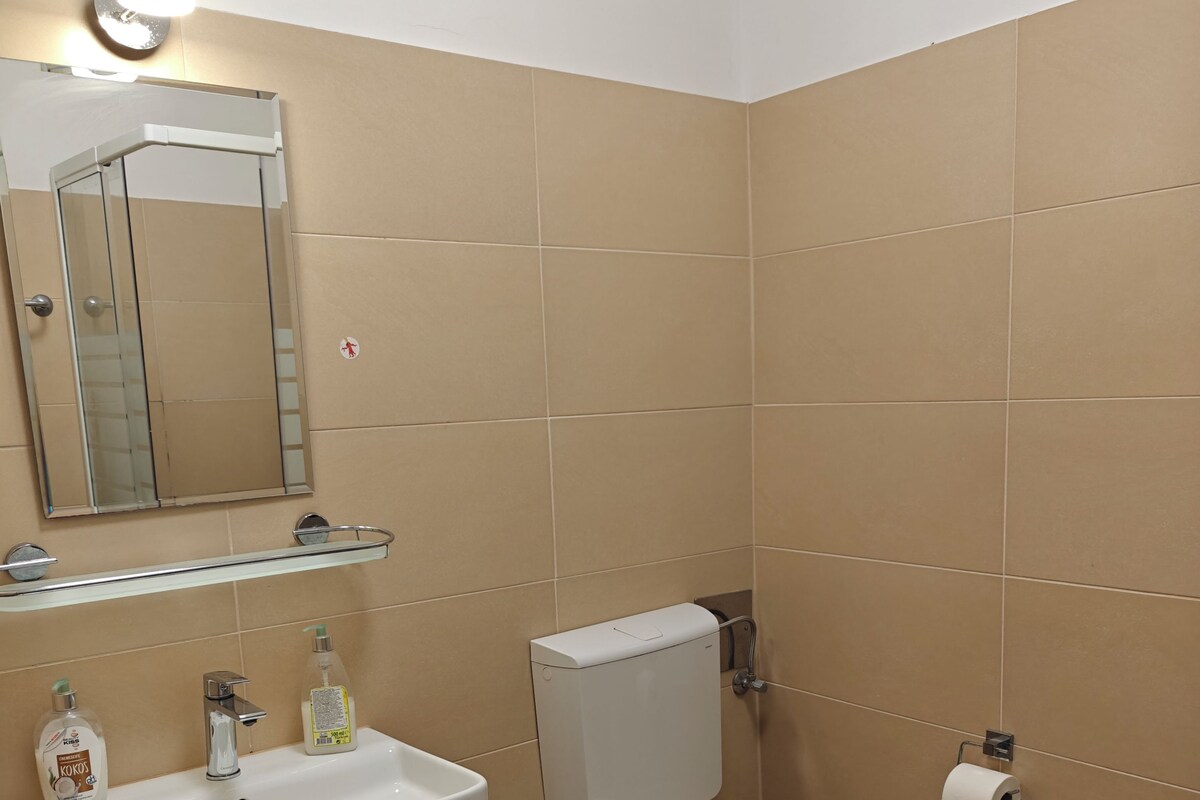 A bathroom with a sink, toilet, and mirror.