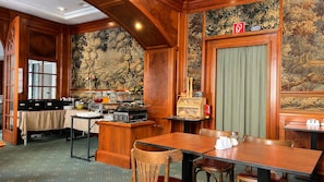 A traditional hotel room with a dining area, a wooden desk, and a mural on the wall. - Hotel Viki (Vienna)
