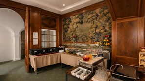 Un buffet de petit-déjeuner proposant une variét é de plats et une grande fresque florale sur le mur.