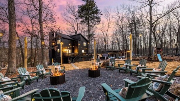 A cabin with a fire pit and outdoor seating. - Escape to the Poconos | Hot Tub, Sauna, Mini-Golf (East Stroudsburg)