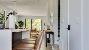 Una cocina moderna con una isla central, asientos tipo banco de madera y vistas al exterior.