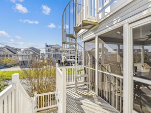 A residential building with a balcony, a staircase, and large windows.