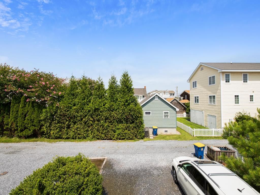 A residential area with houses, a driveway, and a parked car.